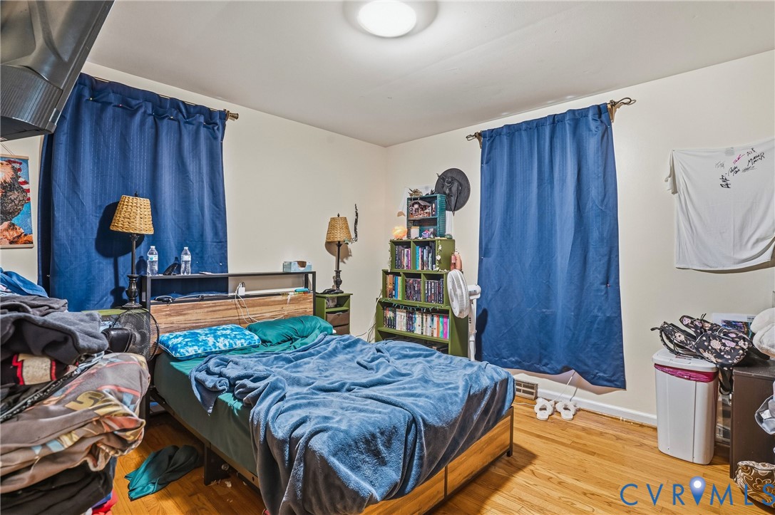 14219 Spruce Avenue Chester, VA 23836 - Photo 17 of 32 a bedroom with a bed and a bookshelf with wooden floor