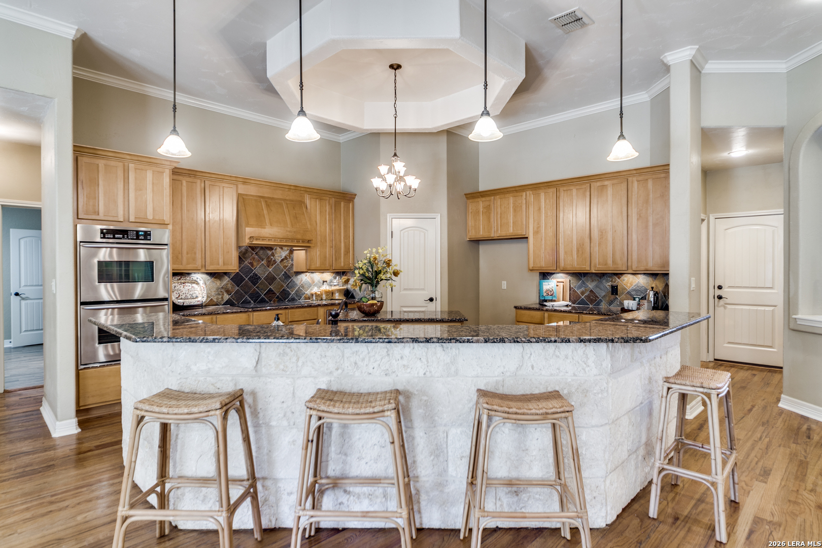 386 Wentworth Spring Branch, TX 78070 - Photo 7 of 30 a kitchen with stainless steel appliances granite countertop stools a sink cabinets and microwave