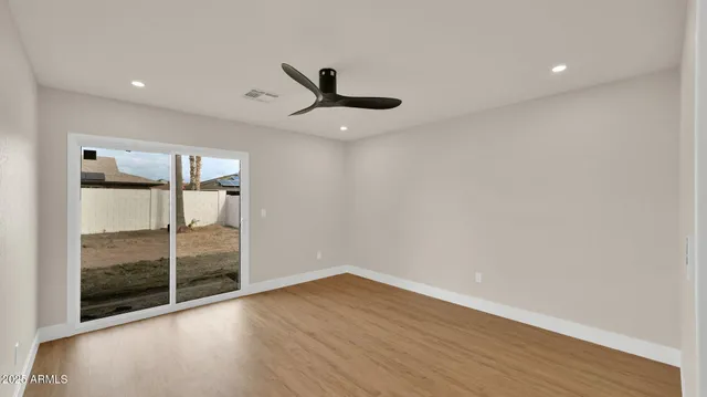 a view of a big room with wooden floor and windows