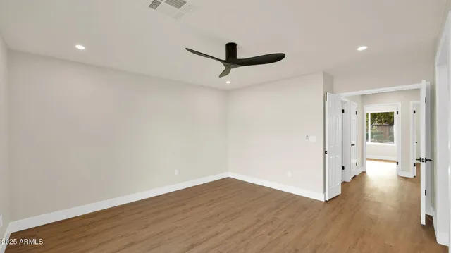 a view of a room with wooden floor and a ceiling fan