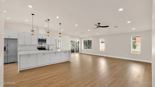 a large kitchen with lots of counter space wooden floor and appliances
