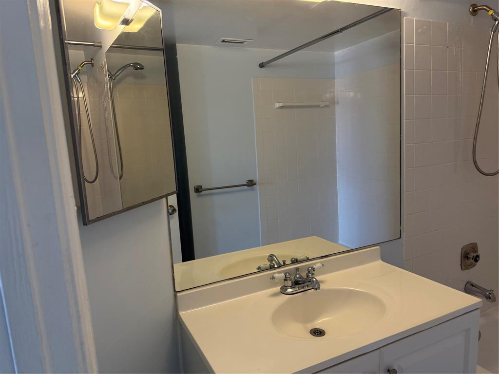 9930 Twin Lakes Drive, Unit 7L Coral Springs, FL 33071 - Photo 26 of 39 a bathroom with a sink mirror and shower