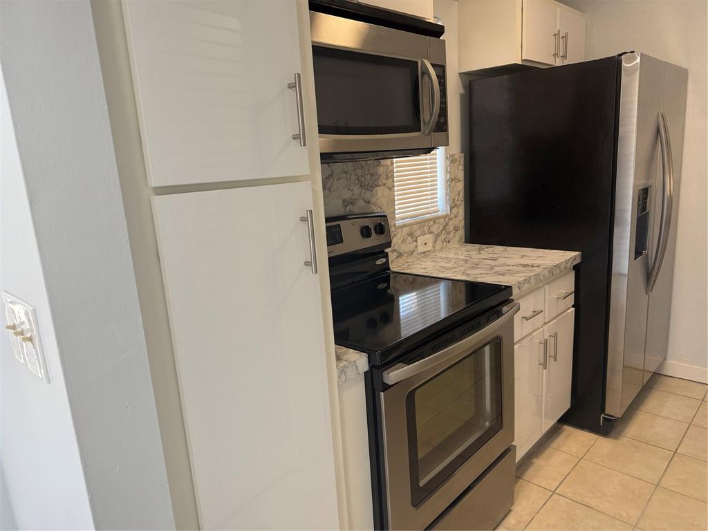 9930 Twin Lakes Drive, Unit 7L Coral Springs, FL 33071 - Photo 3 of 39 a kitchen with stainless steel appliances granite countertop a refrigerator and a stove