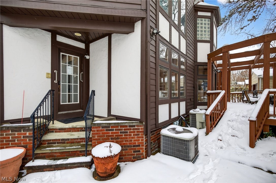 3498 Bainbridge Road Cleveland Heights, OH 44118 - Photo 6 of 50 Snow covered property entrance with stucco siding and brick siding