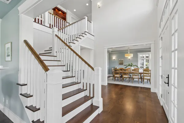 a dining room with furniture a chandelier and wooden floor