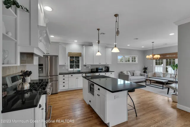 a kitchen with stainless steel appliances granite countertop a sink stove and refrigerator