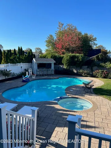 a view of a swimming pool with lawn chairs under an umbrella