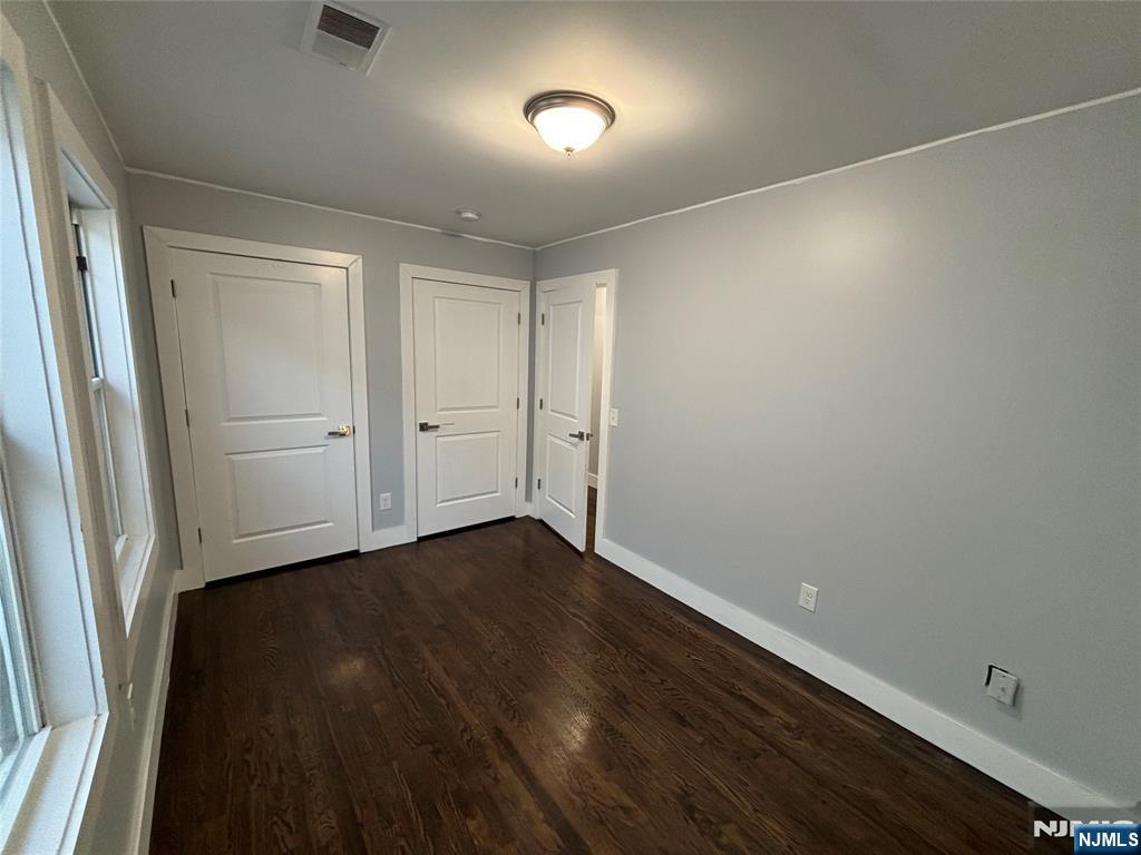 120 Hamilton Avenue, Unit 2 Paterson, NJ 07501 - Photo 2 of 5 an empty room with wooden floor and windows
