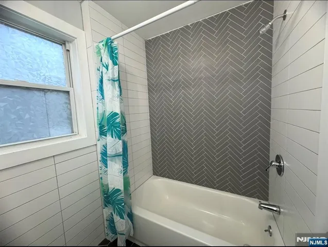 a bathroom with a bathtub and shower