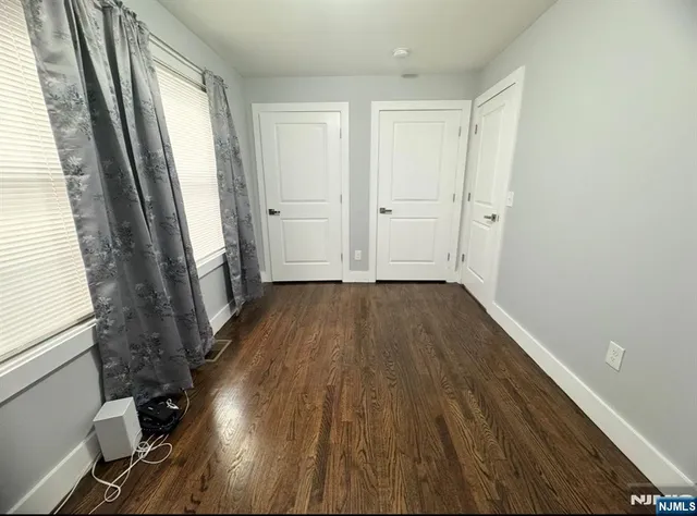 a view of a room with wooden floor and a window