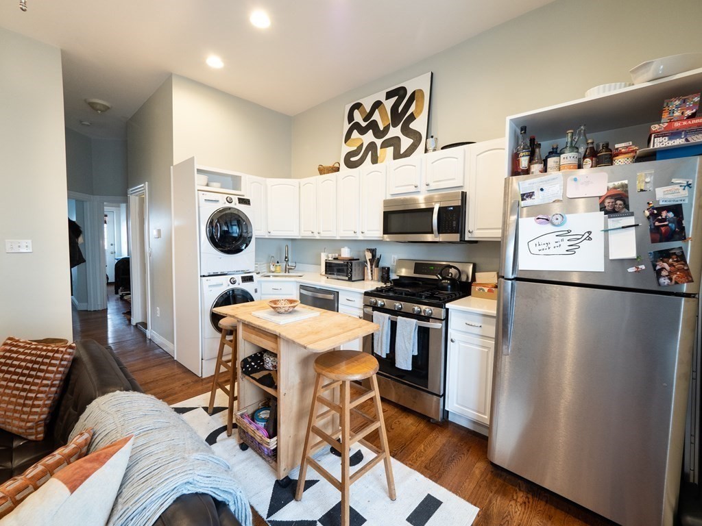25 Fort Avenue, Unit 2 Boston, MA 02119 - Photo 2 of 12 a kitchen with a refrigerator a stove and a microwave