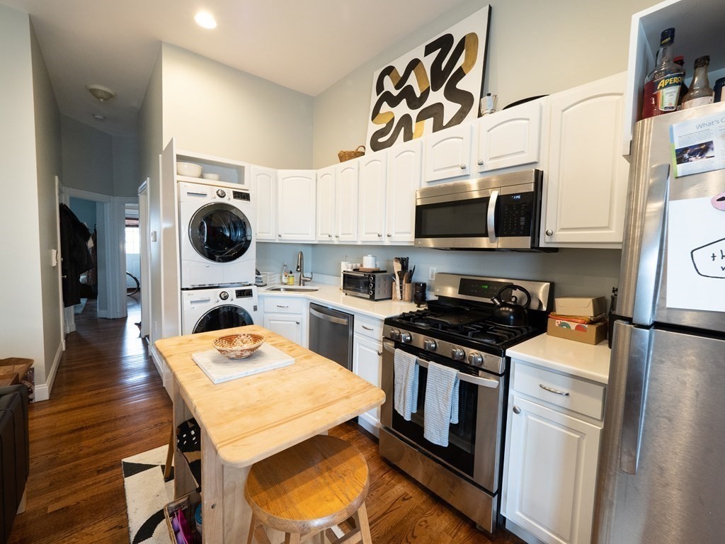25 Fort Avenue, Unit 2 Boston, MA 02119 - Photo 5 of 12 a kitchen with a stove a sink and a refrigerator