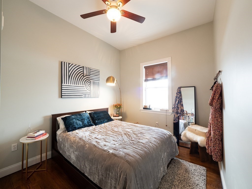 25 Fort Avenue, Unit 2 Boston, MA 02119 - Photo 8 of 12 a bedroom with a large bed and a chandelier