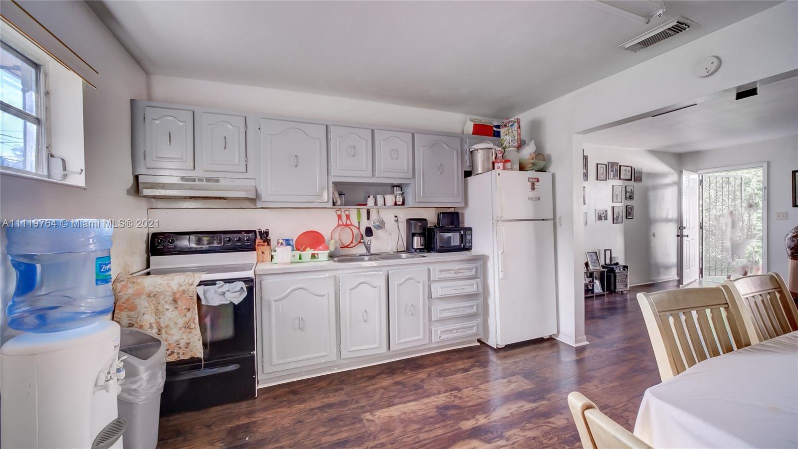 285 Northwest 97th Street Miami, FL 33150 - Photo 17 of 28 a kitchen with white cabinets and refrigerator
