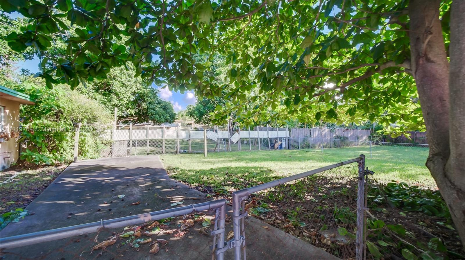 285 Northwest 97th Street Miami, FL 33150 - Photo 20 of 28 a view of a backyard with wooden fence