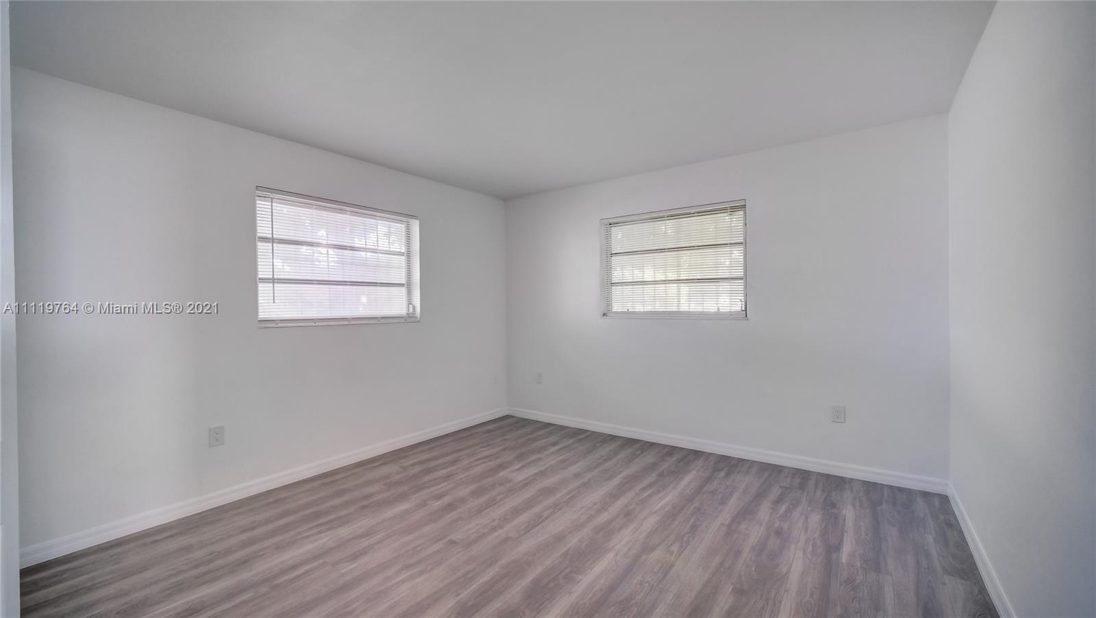 285 Northwest 97th Street Miami, FL 33150 - Photo 3 of 28 an empty room with wooden floor and windows