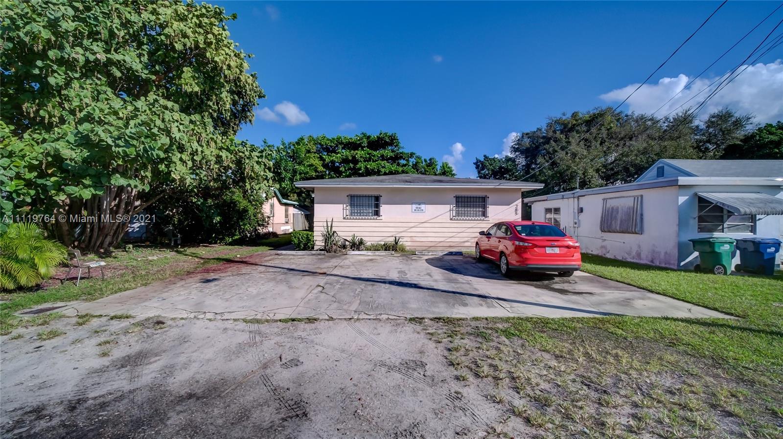 285 Northwest 97th Street Miami, FL 33150 - Photo 25 of 28 a view of a house with truck parked on a road near a forest