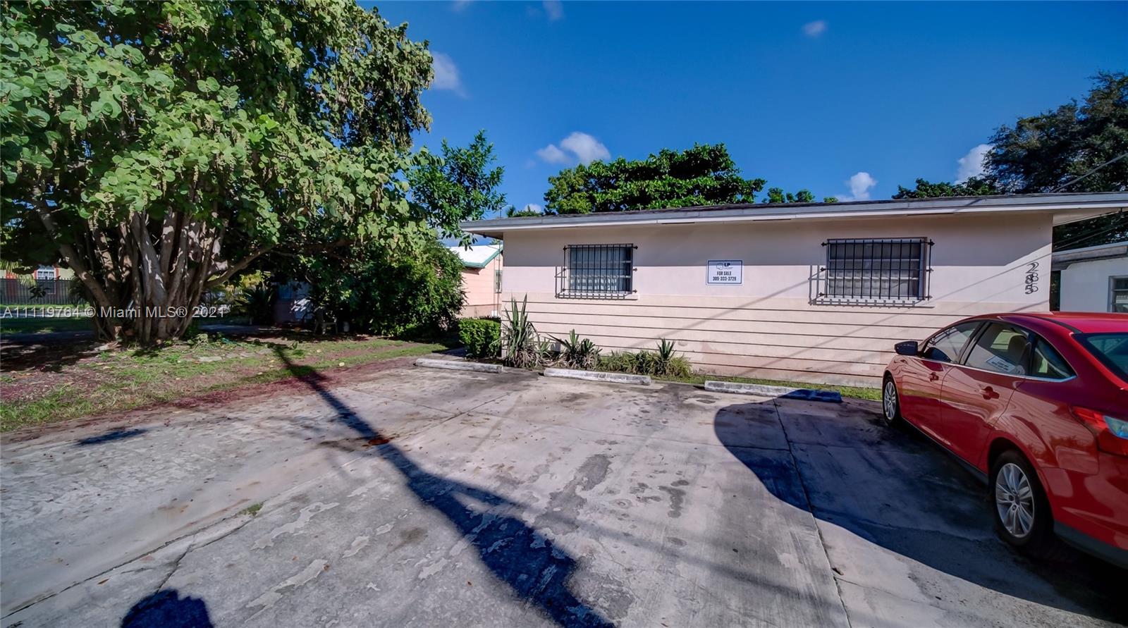 285 Northwest 97th Street Miami, FL 33150 - Photo 26 of 28 a front view of house with yard and trees in the background