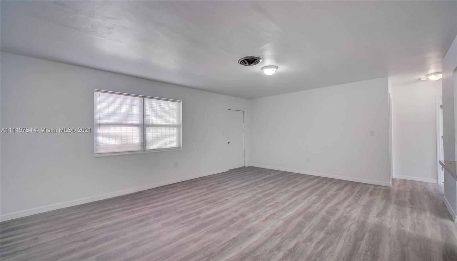 285 Northwest 97th Street Miami, FL 33150 - Photo 5 of 28 an empty room with wooden floor and windows