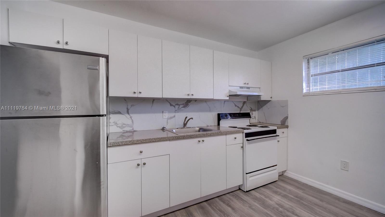 285 Northwest 97th Street Miami, FL 33150 - Photo 8 of 28 a kitchen with stainless steel appliances granite countertop a sink stove and refrigerator