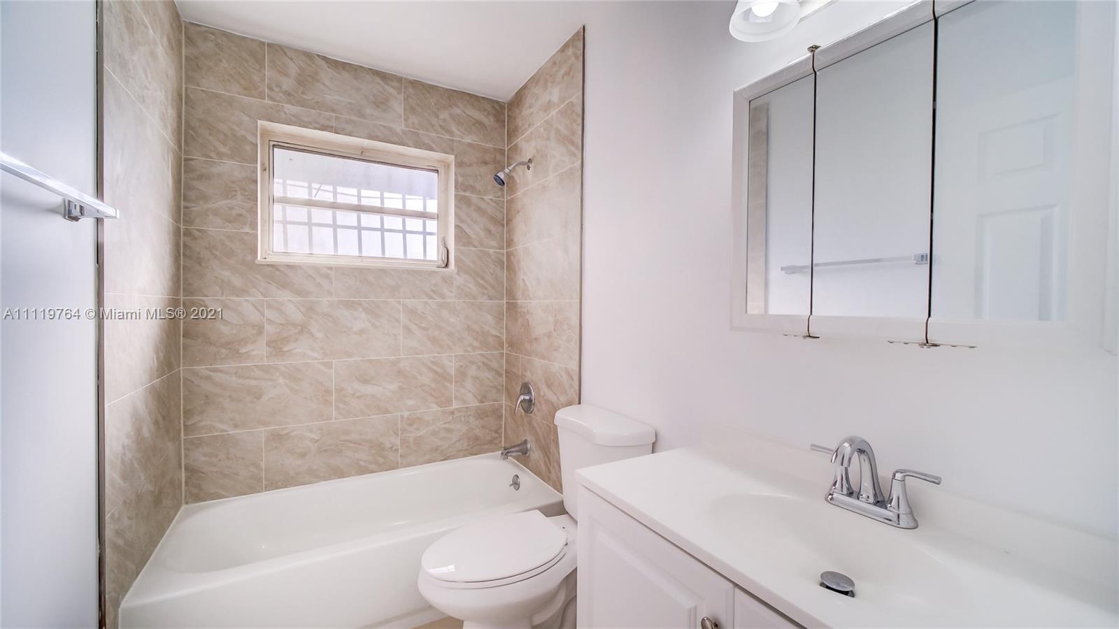 285 Northwest 97th Street Miami, FL 33150 - Photo 9 of 28 a bathroom with a bathtub shower sink vanity and toilet