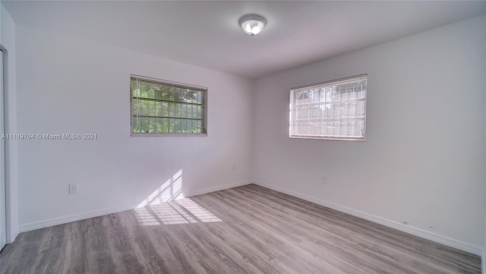 285 Northwest 97th Street Miami, FL 33150 - Photo 10 of 28 an empty room with wooden floor and windows