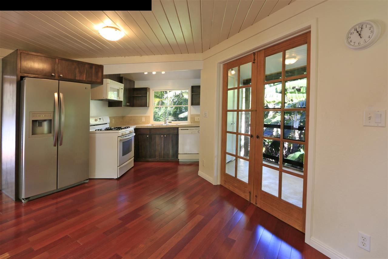 11 Kane Place Haiku, HI 96708 - Photo 12 of 30 a kitchen with stainless steel appliances granite countertop a refrigerator a stove top oven and wooden floor