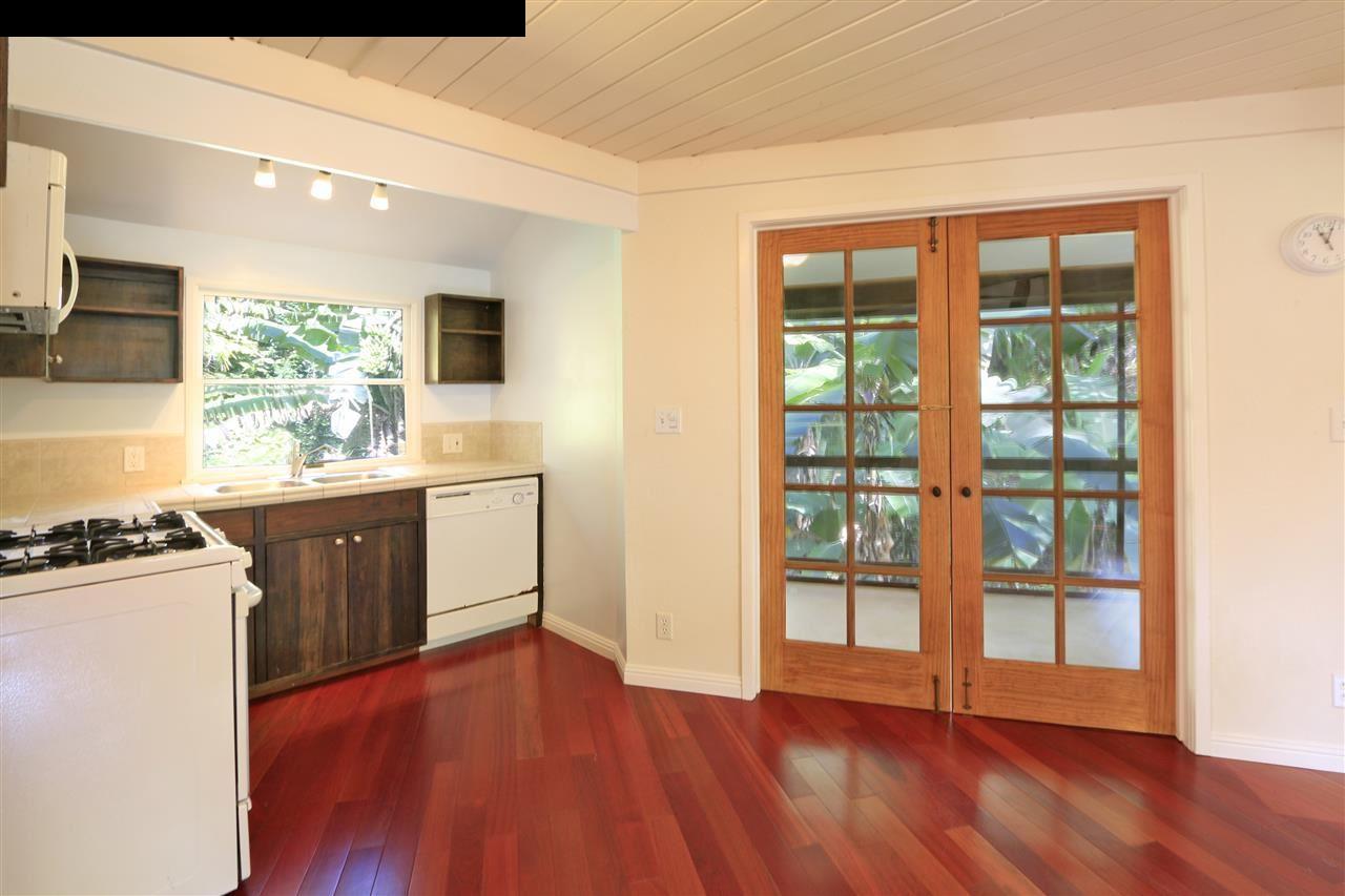 11 Kane Place Haiku, HI 96708 - Photo 3 of 30 a kitchen with wooden floors and white stainless steel appliances