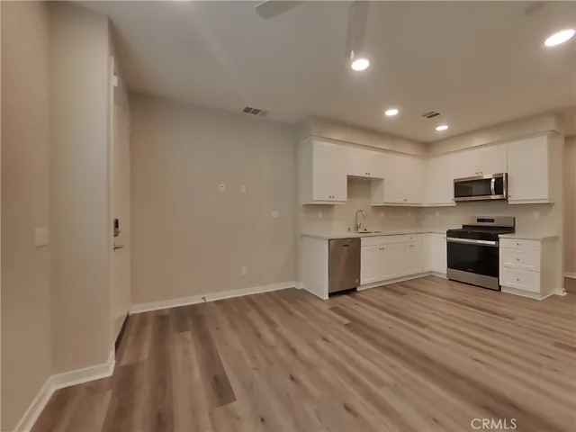 a view of kitchen with granite countertop cabinets and refrigerator