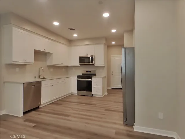 a kitchen with granite countertop a stove top oven and cabinets