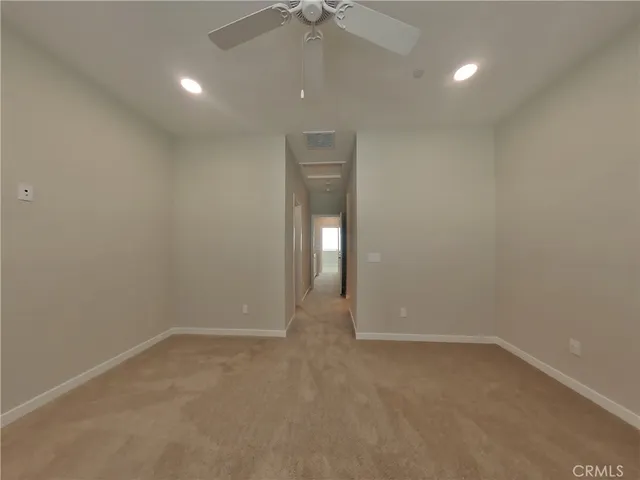 en empty room with windows and fan