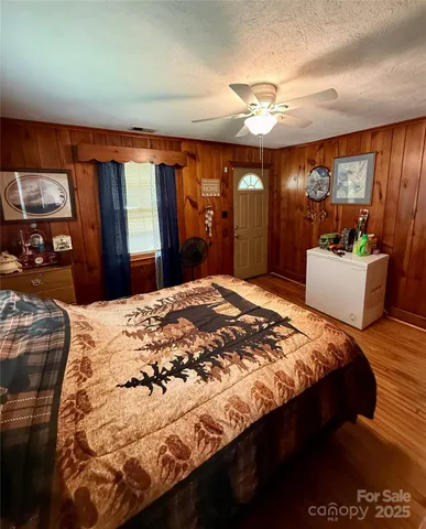 a spacious bedroom with a large bed and a chandelier