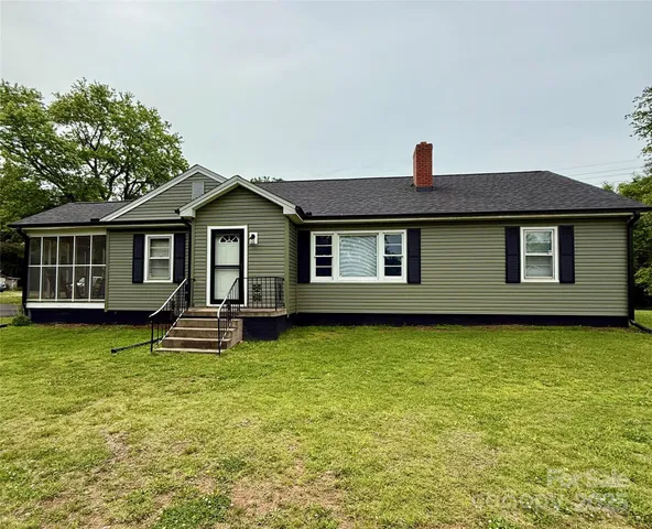 a front view of a house with yard and trees