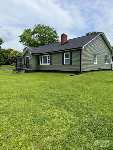 a front view of house with yard and trees