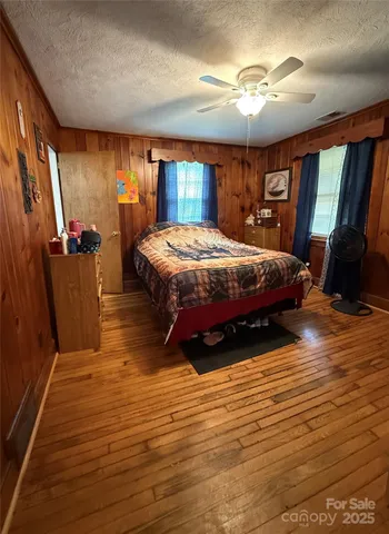 a spacious bedroom with a bed and wooden floor