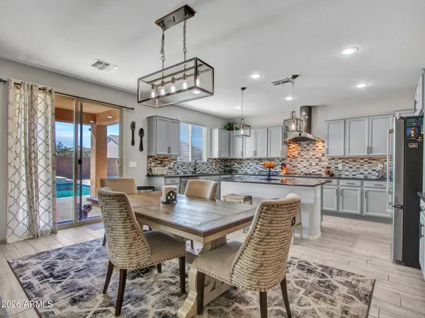 a bedroom with a large bed chandelier and a window