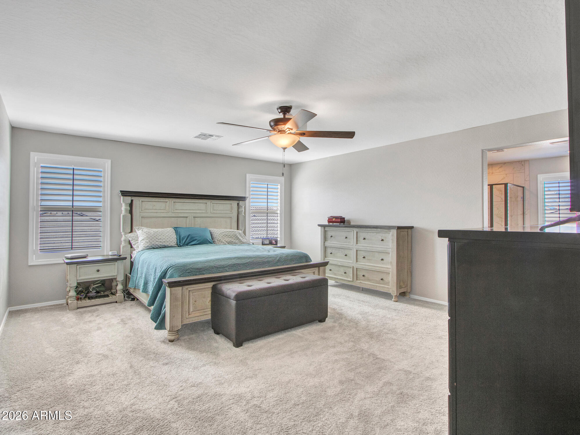 18971 West Clinton Street Surprise, AZ 85388 - Photo 42 of 91 a spacious bedroom with a bed and a chandelier
