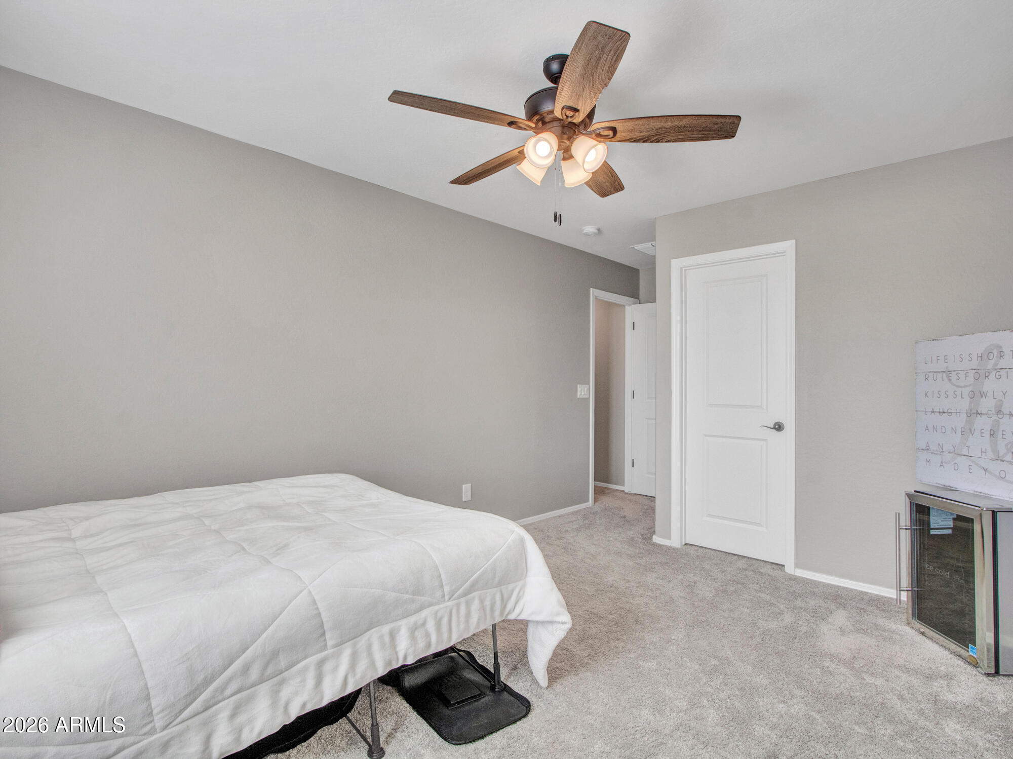 18971 West Clinton Street Surprise, AZ 85388 - Photo 49 of 91 a bedroom with a large bed chandelier and a window