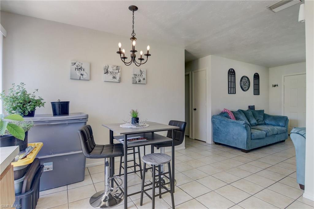 4209 Skyline Boulevard, Unit 4209 Cape Coral, FL 33914 - Photo 12 of 23 a view of a dining room with furniture and chandelier