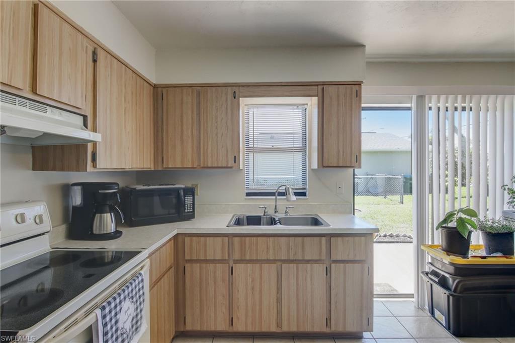 4209 Skyline Boulevard, Unit 4209 Cape Coral, FL 33914 - Photo 13 of 23 a kitchen with a sink a stove cabinets and a window