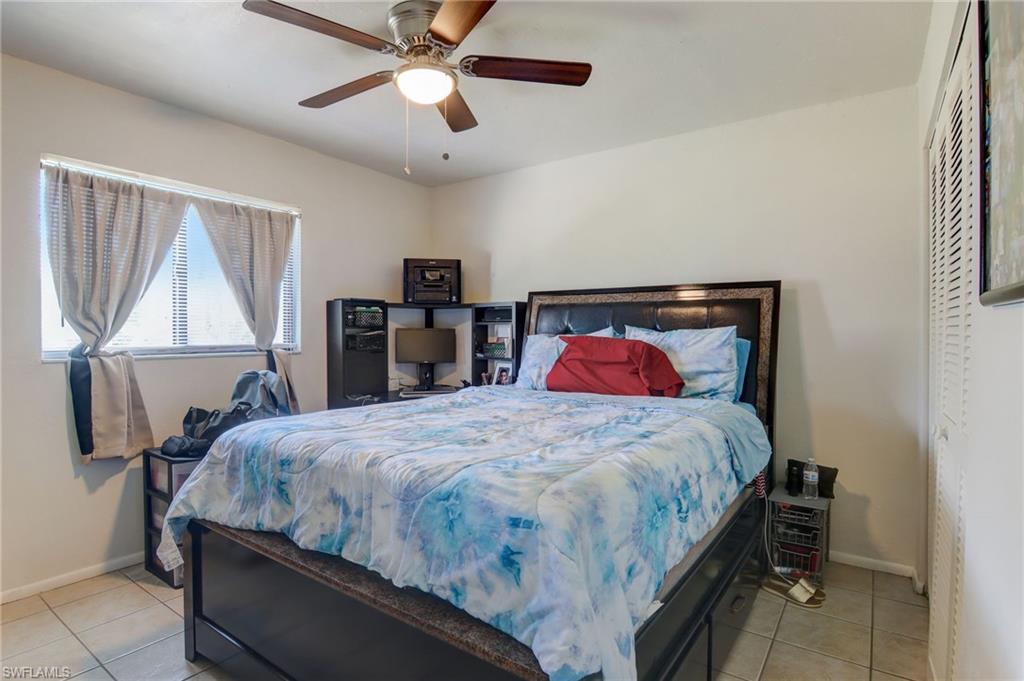 4209 Skyline Boulevard, Unit 4209 Cape Coral, FL 33914 - Photo 15 of 23 a bedroom with a bed and a chandelier