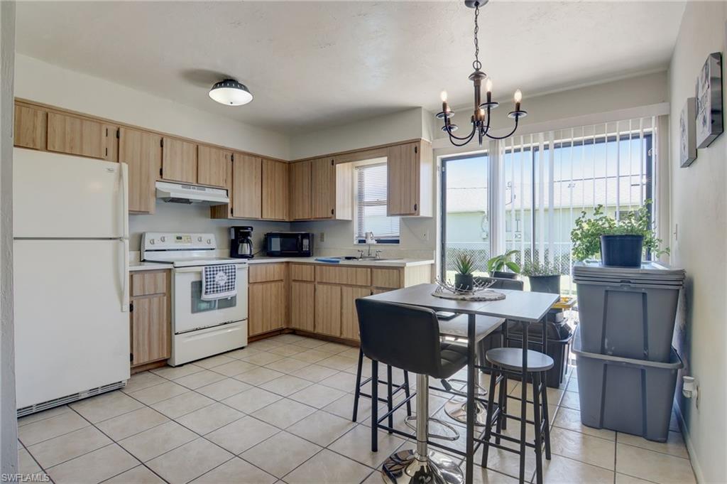 4209 Skyline Boulevard, Unit 4209 Cape Coral, FL 33914 - Photo 18 of 23 a kitchen with a table chairs refrigerator and cabinets