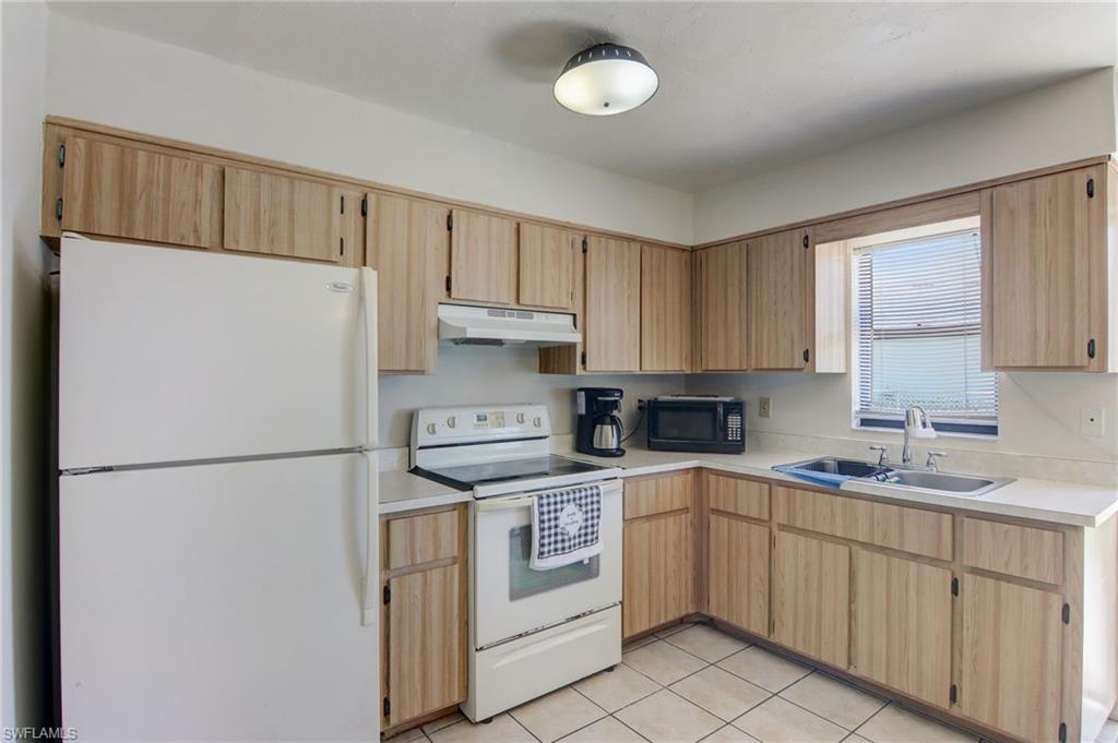 4209 Skyline Boulevard, Unit 4209 Cape Coral, FL 33914 - Photo 19 of 23 a kitchen with white cabinets and white appliances