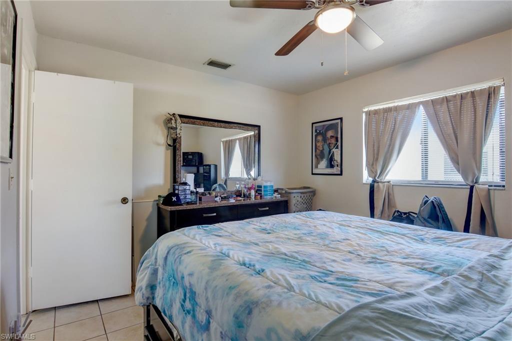 4209 Skyline Boulevard, Unit 4209 Cape Coral, FL 33914 - Photo 8 of 23 a bedroom with a large bed and a chandelier