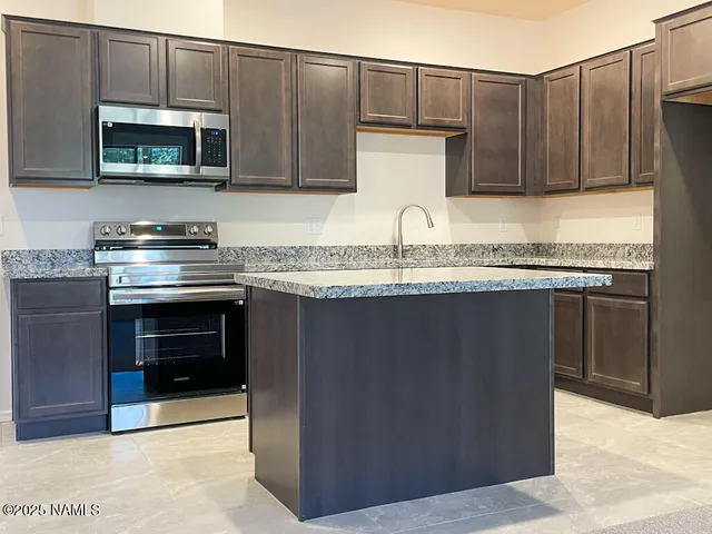 a kitchen with stainless steel appliances granite countertop a stove and a microwave