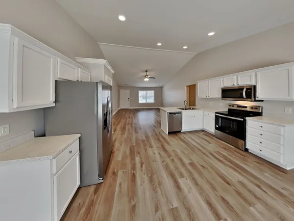 a kitchen with cabinets and wooden floor