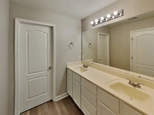 a bathroom with a double vanity sink and a mirror