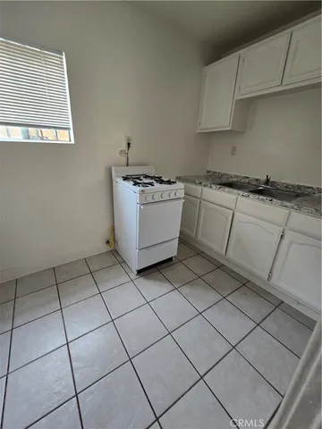 a kitchen with a stove top oven sink and cabinets