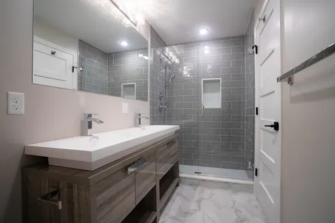 a bathroom with a sink a toilet and shower