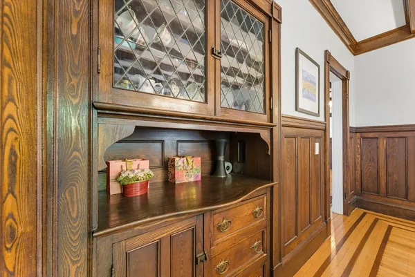 a dining room with chandelier fan and wooden floor